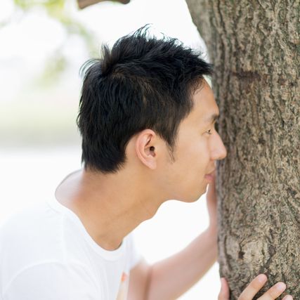 木に隠れている男性