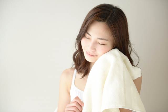 タオルで顔をふく女性