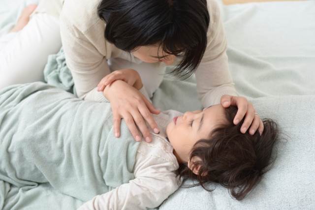 子供を寝かすお母さん